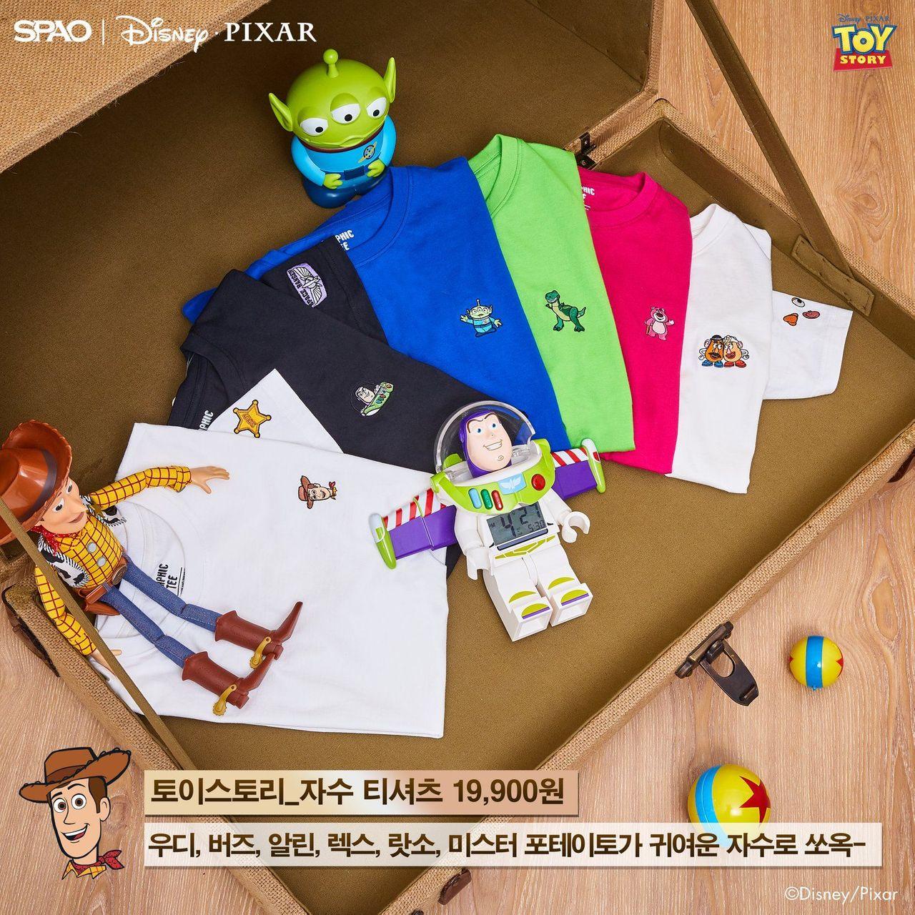 ชุดเสื้อยืดคอลเลคชั่น Toy Story จาก SPAO ประกอบด้วยเสื้อหลากสีแสดงคาแร็กเตอร์ต่าง ๆ เช่น Woody, Buzz และ Rex วางอยู่บนกระเป๋าเดินทาง